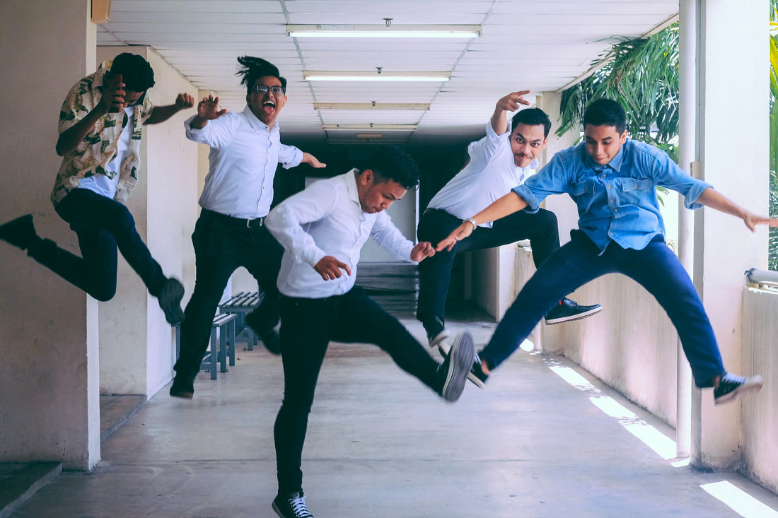 Group of co-workers jumping happily, good wok culture