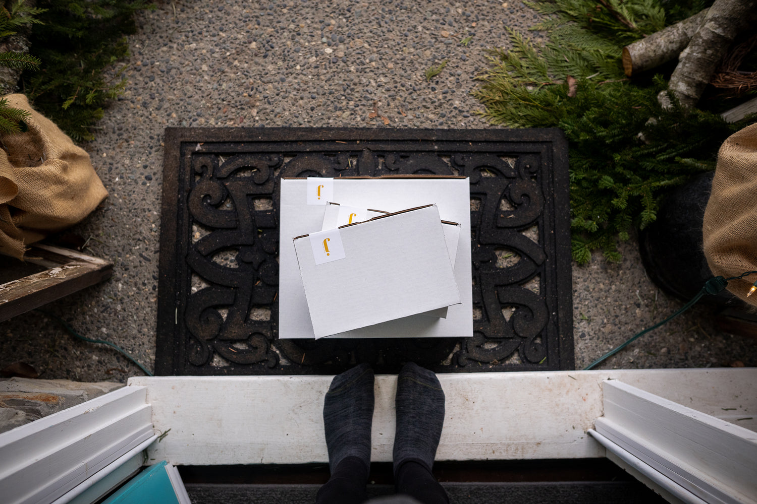 shipping boxes at front door step on doormat